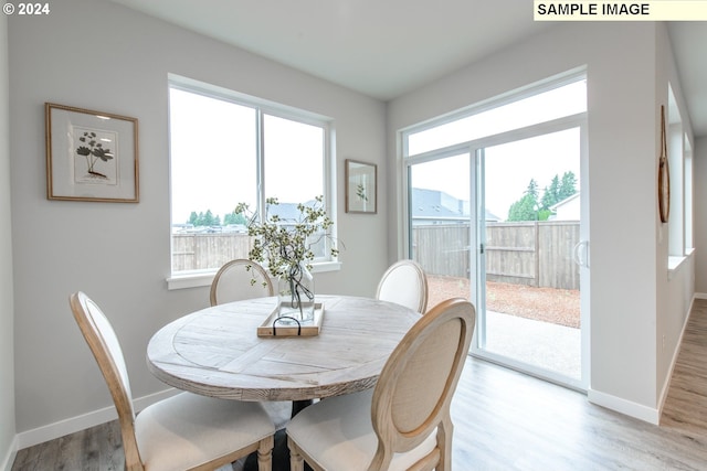 dining area featuring baseboards, light wood-type flooring, and a wealth of natural light