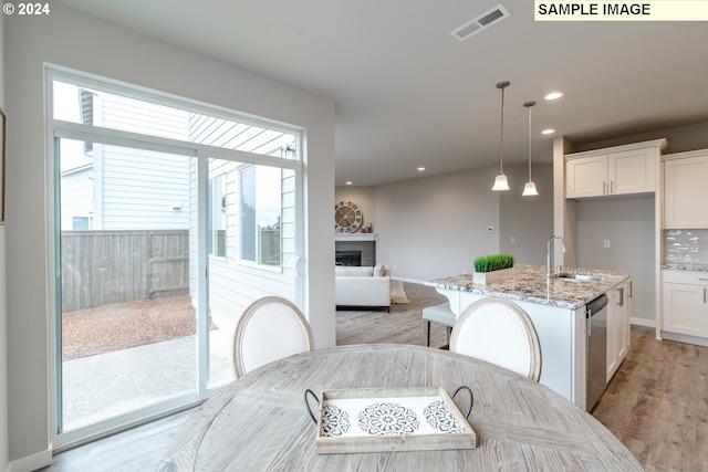 kitchen with a sink, visible vents, white cabinets, and a fireplace