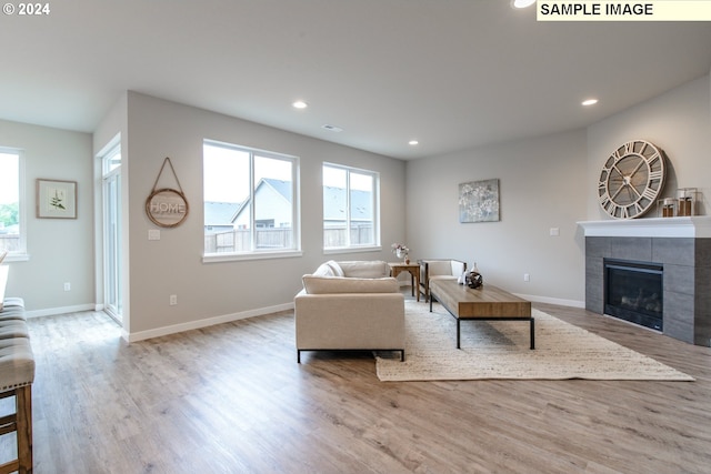 living room with wood finished floors, recessed lighting, a fireplace, and baseboards