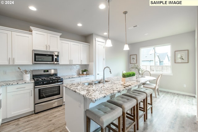 kitchen featuring visible vents, a sink, decorative backsplash, white cabinets, and appliances with stainless steel finishes