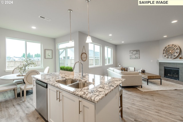 kitchen featuring dishwasher, open floor plan, visible vents, and a sink