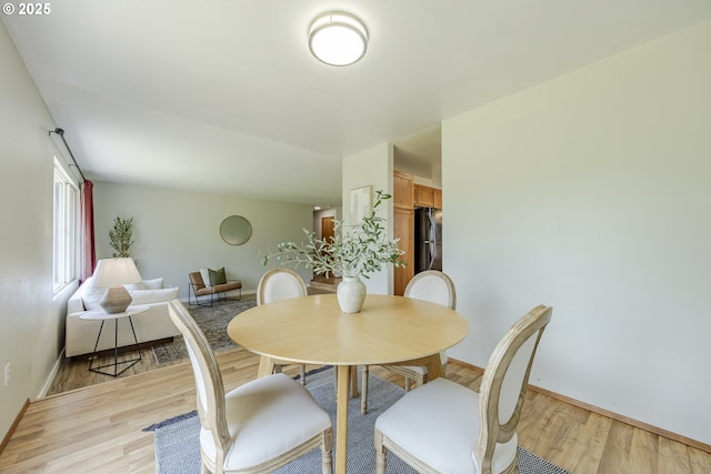 dining area with baseboards and light wood finished floors