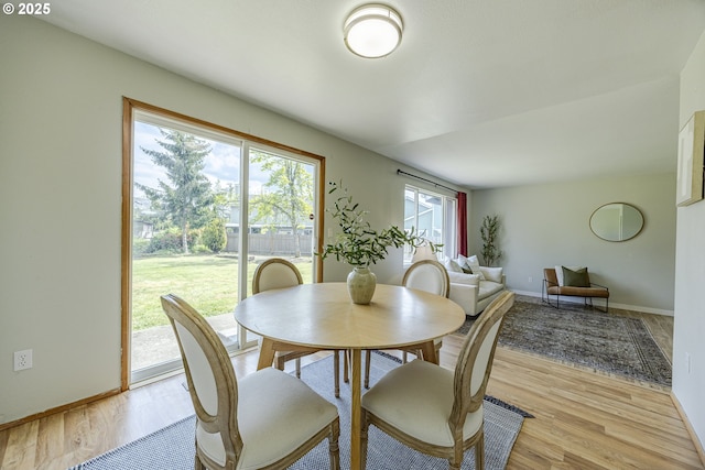 dining space featuring baseboards and light wood-style floors