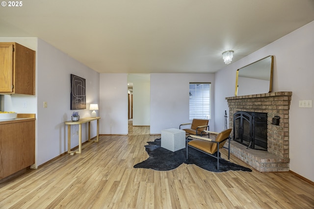 living room with a fireplace, baseboards, and light wood-type flooring