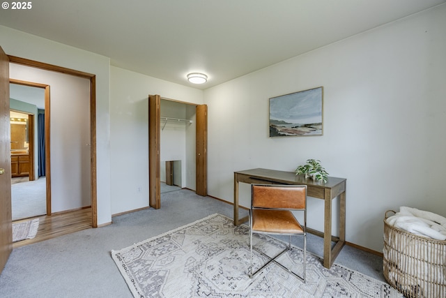carpeted office featuring baseboards