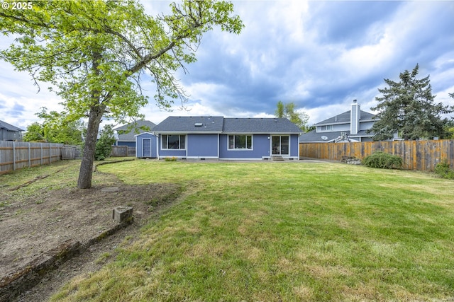 rear view of property featuring an outdoor structure, a fenced backyard, a shed, and a yard