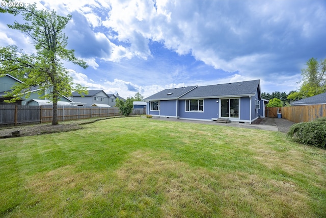 rear view of house featuring a lawn, a fenced backyard, a patio area, and roof with shingles