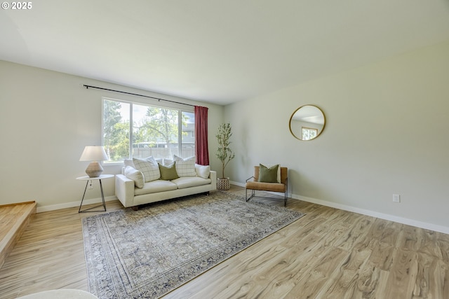 living area with baseboards and wood finished floors