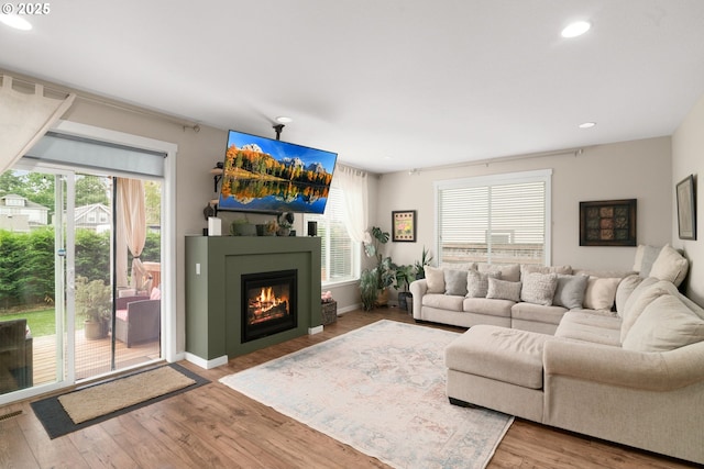 6910 SE Lamphier St, Milwaukie, OR 97222 - living room with healthy amount of natural light, a glass covered fireplace, wood finished floors, recessed lighting, and baseboards