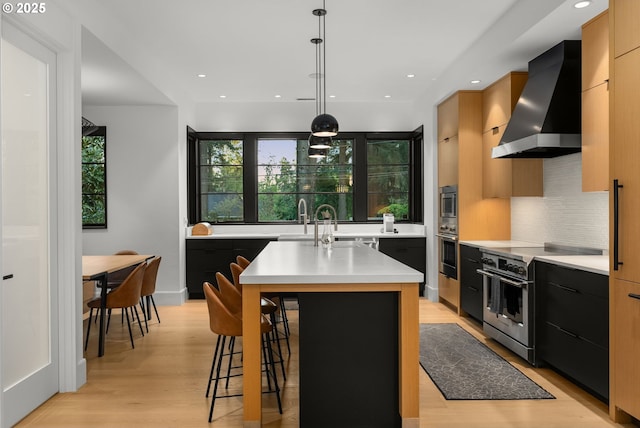 1235 Andrews Rd, Lake Oswego, OR 97034 - kitchen with wall chimney range hood, appliances with stainless steel finishes, modern cabinets, light countertops, and dark cabinets