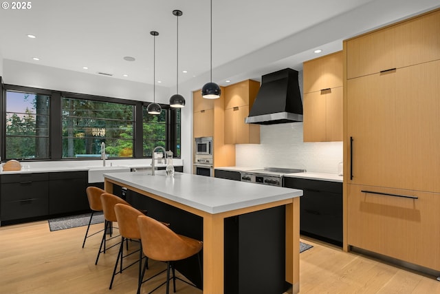 1235 Andrews Rd, Lake Oswego, OR 97034 - kitchen featuring wall chimney exhaust hood, modern cabinets, appliances with stainless steel finishes, light countertops, and recessed lighting