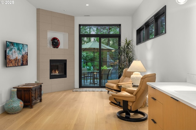 1235 Andrews Rd, Lake Oswego, OR 97034 - sitting room with light wood finished floors, a tiled fireplace, and recessed lighting