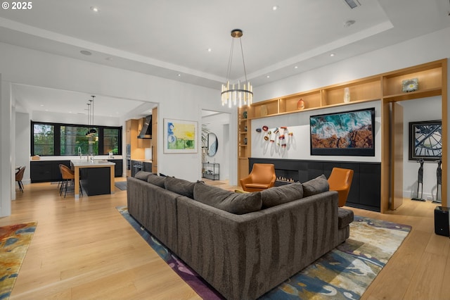 1235 Andrews Rd, Lake Oswego, OR 97034 - living room featuring light wood-style flooring, a raised ceiling, a chandelier, and recessed lighting