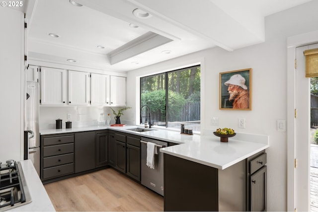 kitchen with a sink, appliances with stainless steel finishes, plenty of natural light, and white cabinetry