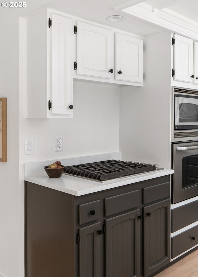kitchen with light countertops, white cabinetry, appliances with stainless steel finishes, and gray cabinetry