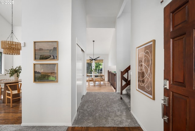 entrance foyer featuring stairway, baseboards, a high ceiling, and dark wood-style floors