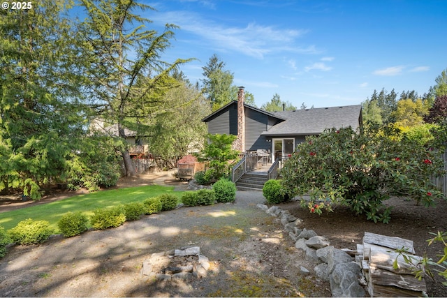exterior space featuring roof with shingles, a chimney, and a deck