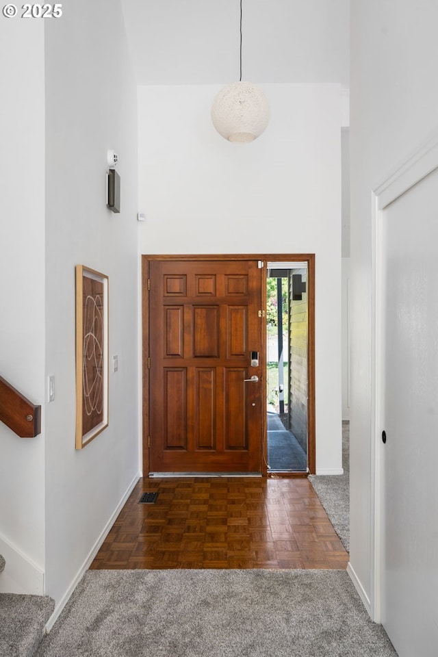 foyer with baseboards, stairs, and a towering ceiling