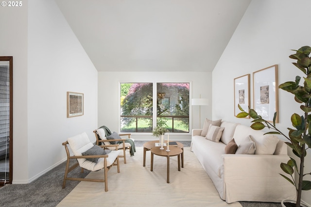 living room featuring high vaulted ceiling, baseboards, and light colored carpet