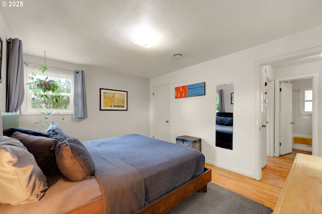 2940 Pearl St, Eugene, OR 97405 - bedroom with light wood finished floors, multiple windows, and a textured ceiling