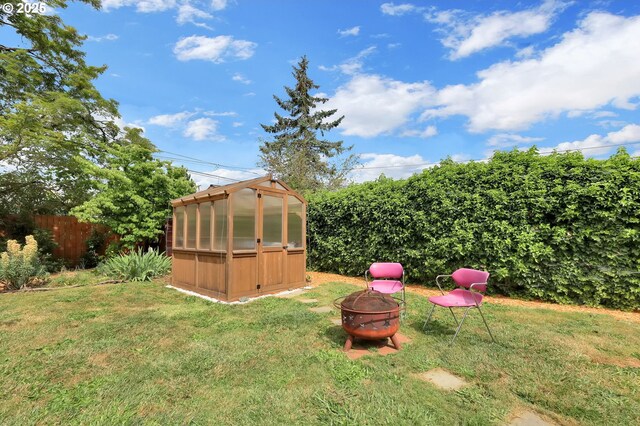2940 Pearl St, Eugene, OR 97405 - view of yard with an exterior structure, an outdoor fire pit, and an outdoor structure