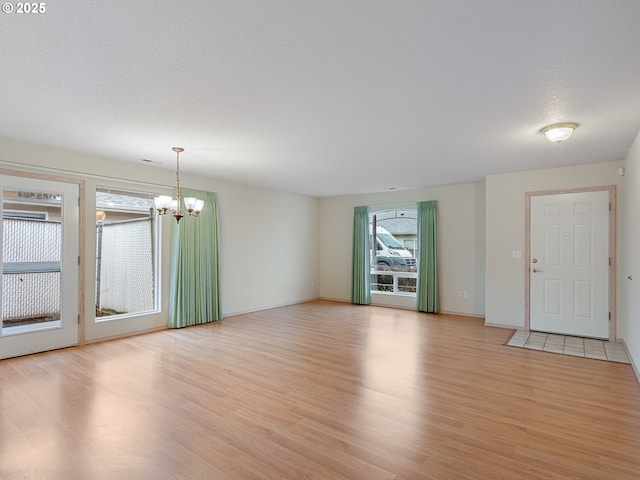 interior space featuring plenty of natural light, light wood-style flooring, and a notable chandelier