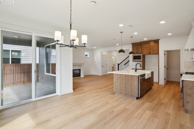 17109 NE 82nd St, Vancouver, WA 98682 - kitchen featuring brown cabinetry, light wood-style floors, open floor plan, light countertops, and appliances with stainless steel finishes