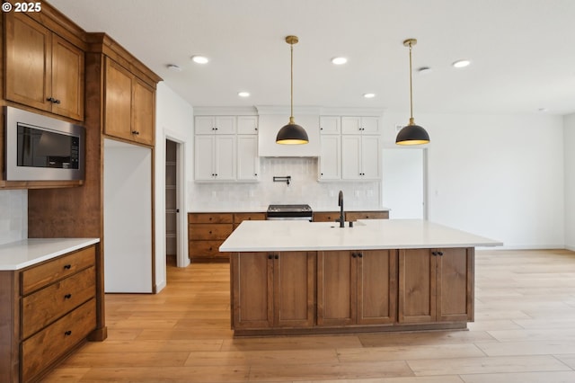 17109 NE 82nd St, Vancouver, WA 98682 - kitchen with light countertops, white cabinetry, light wood finished floors, backsplash, and stainless steel appliances