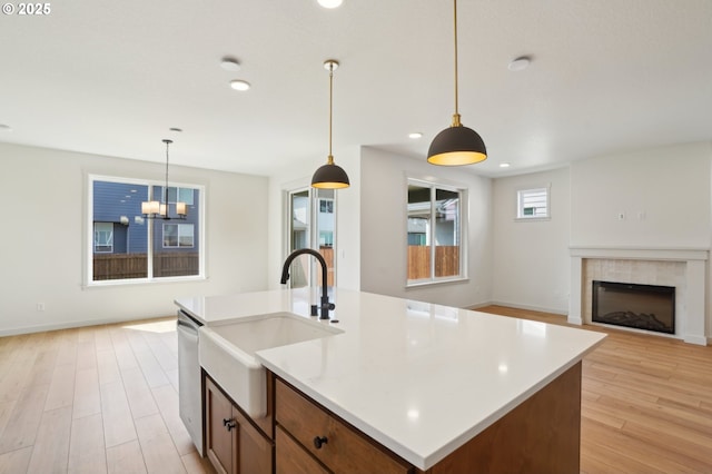 17109 NE 82nd St, Vancouver, WA 98682 - kitchen featuring a sink, light wood-style floors, decorative light fixtures, a tile fireplace, and stainless steel dishwasher