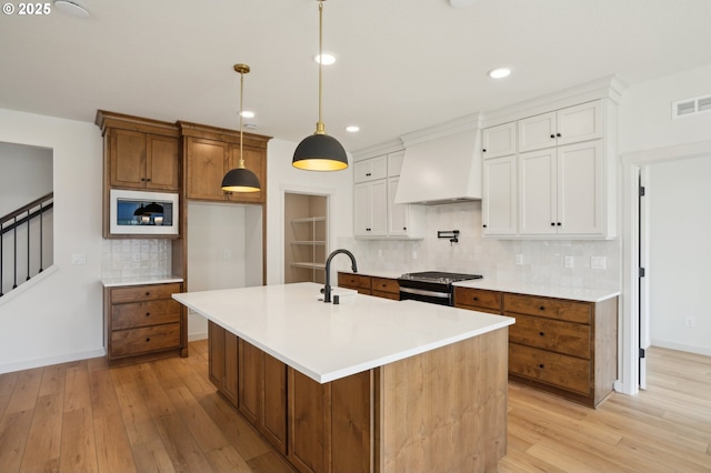 17109 NE 82nd St, Vancouver, WA 98682 - kitchen featuring premium range hood, light wood finished floors, stainless steel range with gas cooktop, and visible vents