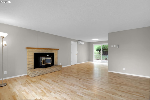 29652 Lusk Rd, Eugene, OR 97405 - unfurnished living room with wood finished floors, an AC wall unit, baseboards, and a textured ceiling