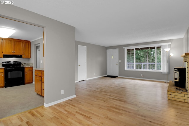 29652 Lusk Rd, Eugene, OR 97405 - unfurnished living room featuring light wood-style flooring, a wood stove, and baseboards