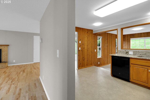 29652 Lusk Rd, Eugene, OR 97405 - kitchen featuring dishwasher, wooden walls, light stone countertops, baseboards, and vaulted ceiling