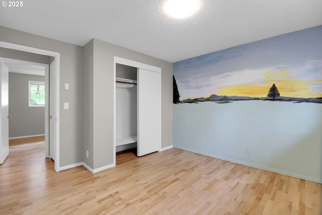 29652 Lusk Rd, Eugene, OR 97405 - unfurnished bedroom with light wood finished floors, baseboards, a closet, and a textured ceiling