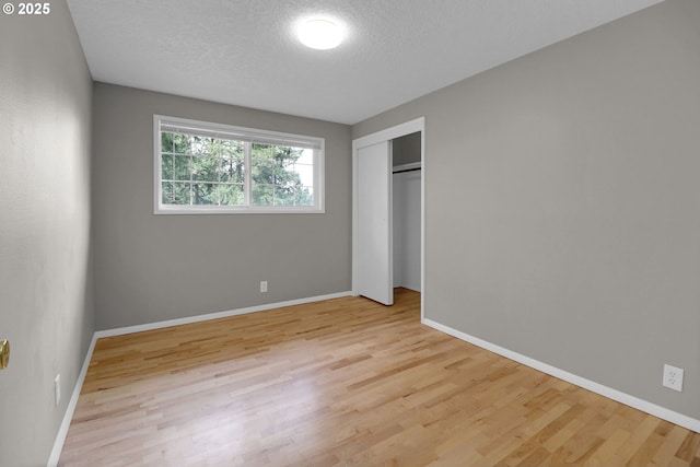 29652 Lusk Rd, Eugene, OR 97405 - unfurnished bedroom with wood finished floors, a textured ceiling, baseboards, and a closet