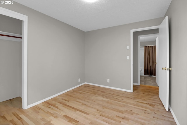 29652 Lusk Rd, Eugene, OR 97405 - unfurnished bedroom featuring light wood finished floors, baseboards, and a textured ceiling