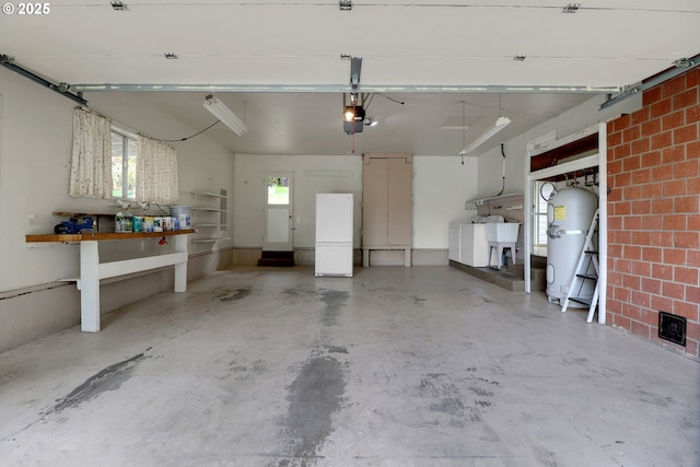 29652 Lusk Rd, Eugene, OR 97405 - garage with a garage door opener, washer and dryer, freestanding refrigerator, and strapped water heater