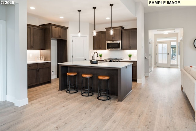4654 NW 71st Ave, Camas, WA 98607 - kitchen featuring stainless steel microwave, backsplash, light countertops, dark brown cabinets, and recessed lighting