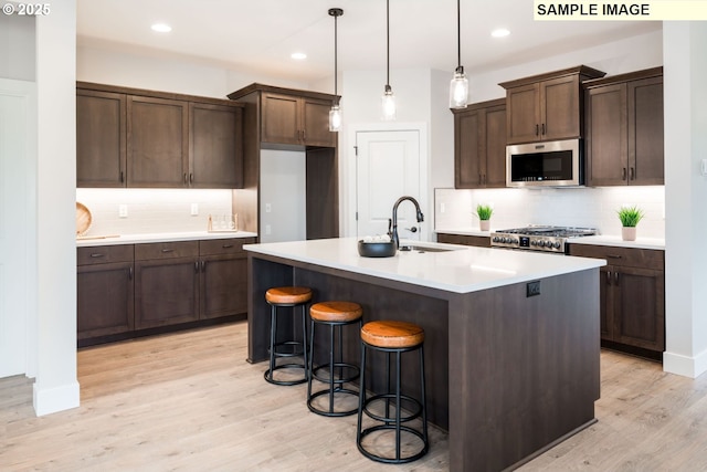 4654 NW 71st Ave, Camas, WA 98607 - kitchen with stainless steel microwave, stove, backsplash, light wood finished floors, and recessed lighting