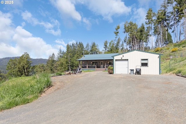 view of front of house with an outdoor structure, a mountain view, and driveway