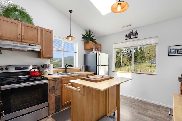 kitchen with wooden counters, visible vents, a sink, under cabinet range hood, and stainless steel appliances