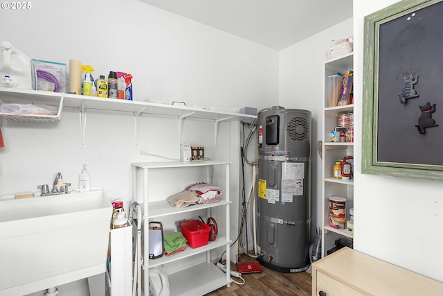 utility room with hybrid water heater and a sink