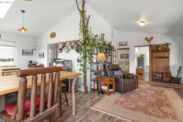 interior space with a skylight, high vaulted ceiling, wood finished floors, and visible vents