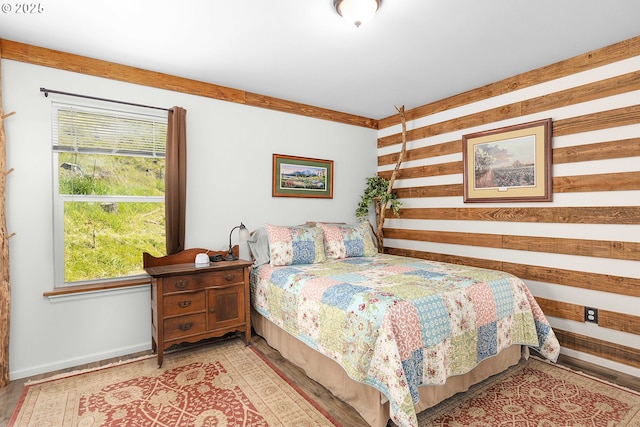 bedroom with baseboards and wood walls