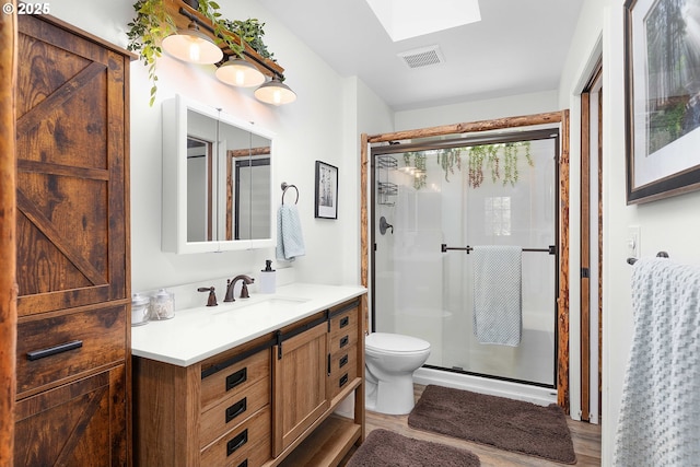 full bathroom with visible vents, a stall shower, a skylight, and vanity