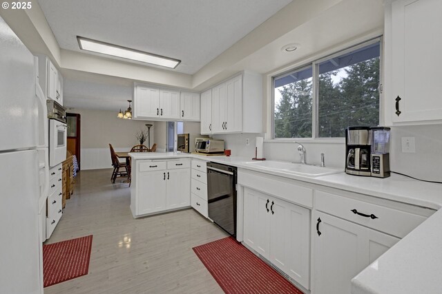 85304 Nestle Way, Pleasant Hill, OR 97455 - kitchen with white appliances, a sink, a peninsula, white cabinets, and light countertops