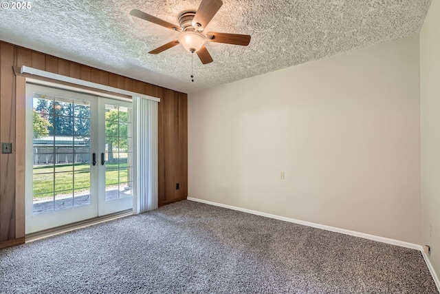 16127 NE Caples Rd, Brush Prairie, WA 98606 - carpeted spare room featuring a textured ceiling, french doors, ceiling fan, and wooden walls