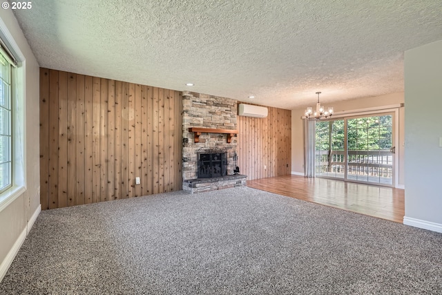16127 NE Caples Rd, Brush Prairie, WA 98606 - unfurnished living room with carpet, a wall mounted AC, a chandelier, a textured ceiling, and wooden walls