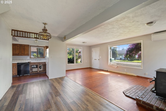 520 Elm Ave, Tillamook, OR 97141 - unfurnished living room with a wood stove, a chandelier, dark wood finished floors, a textured ceiling, and plenty of natural light