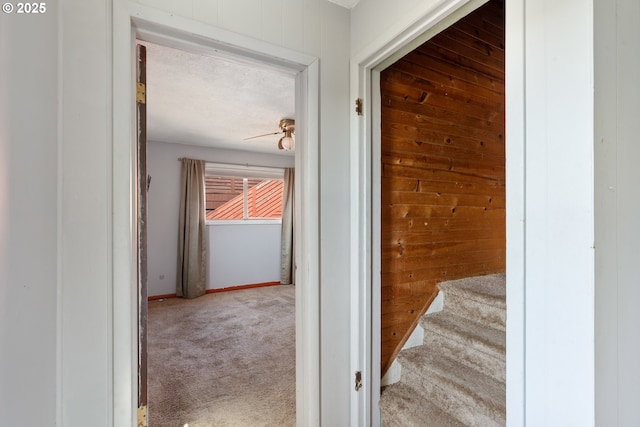 520 Elm Ave, Tillamook, OR 97141 - hallway featuring carpet flooring, wooden walls, baseboards, and stairway